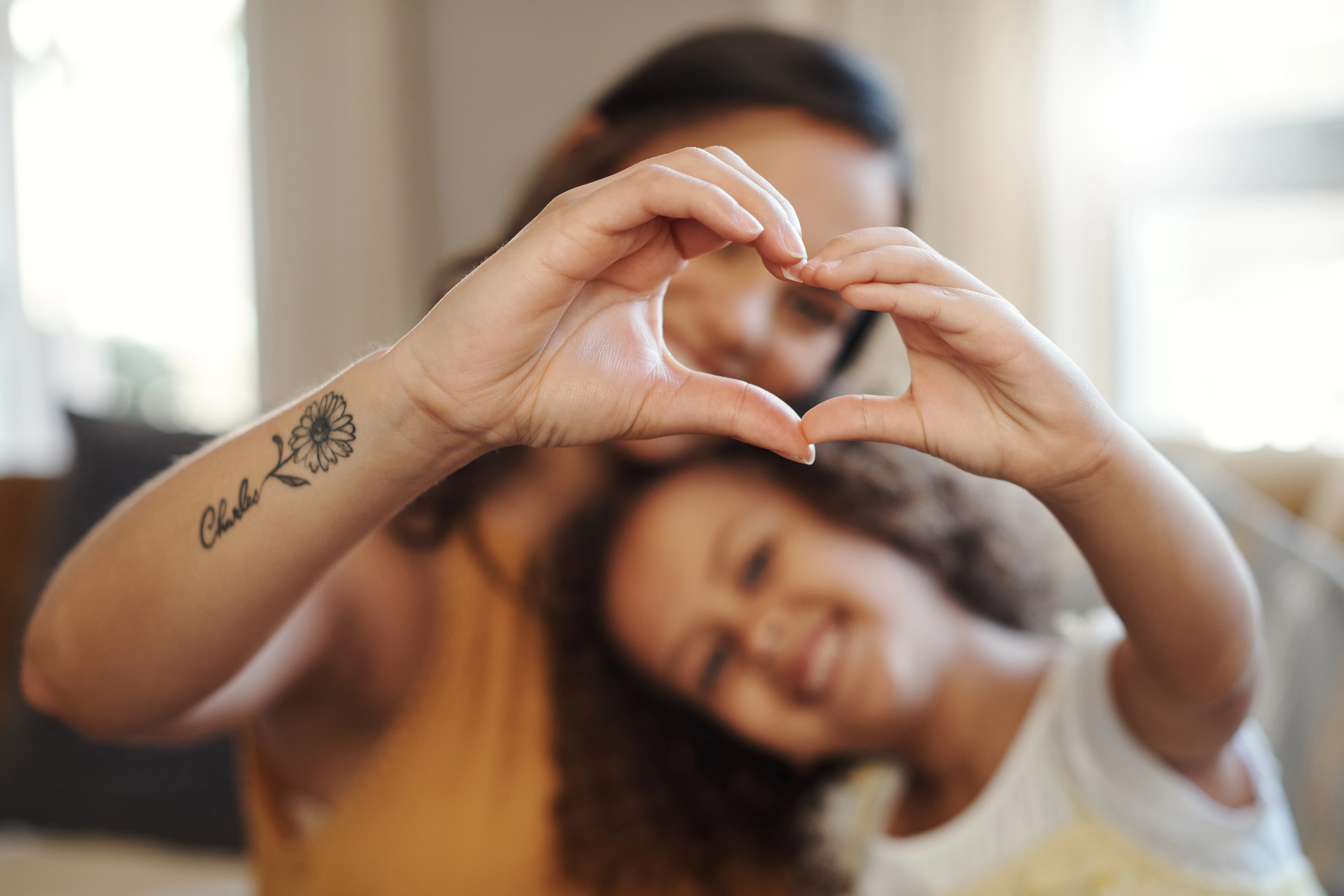 Kind und Mutter formen mit ihren Händen zusammen ein Herz