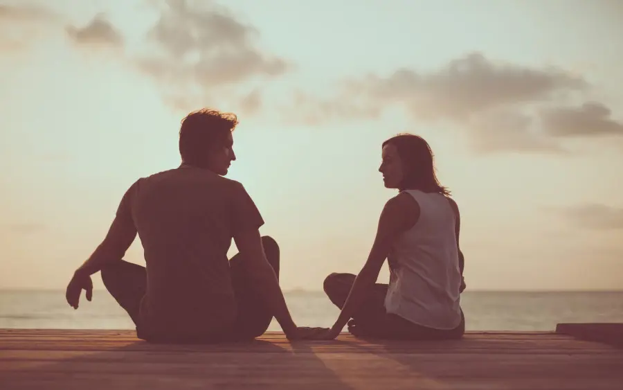 Ein Paar sitzt am Meer und führt ein tiefgründiges Gespräch